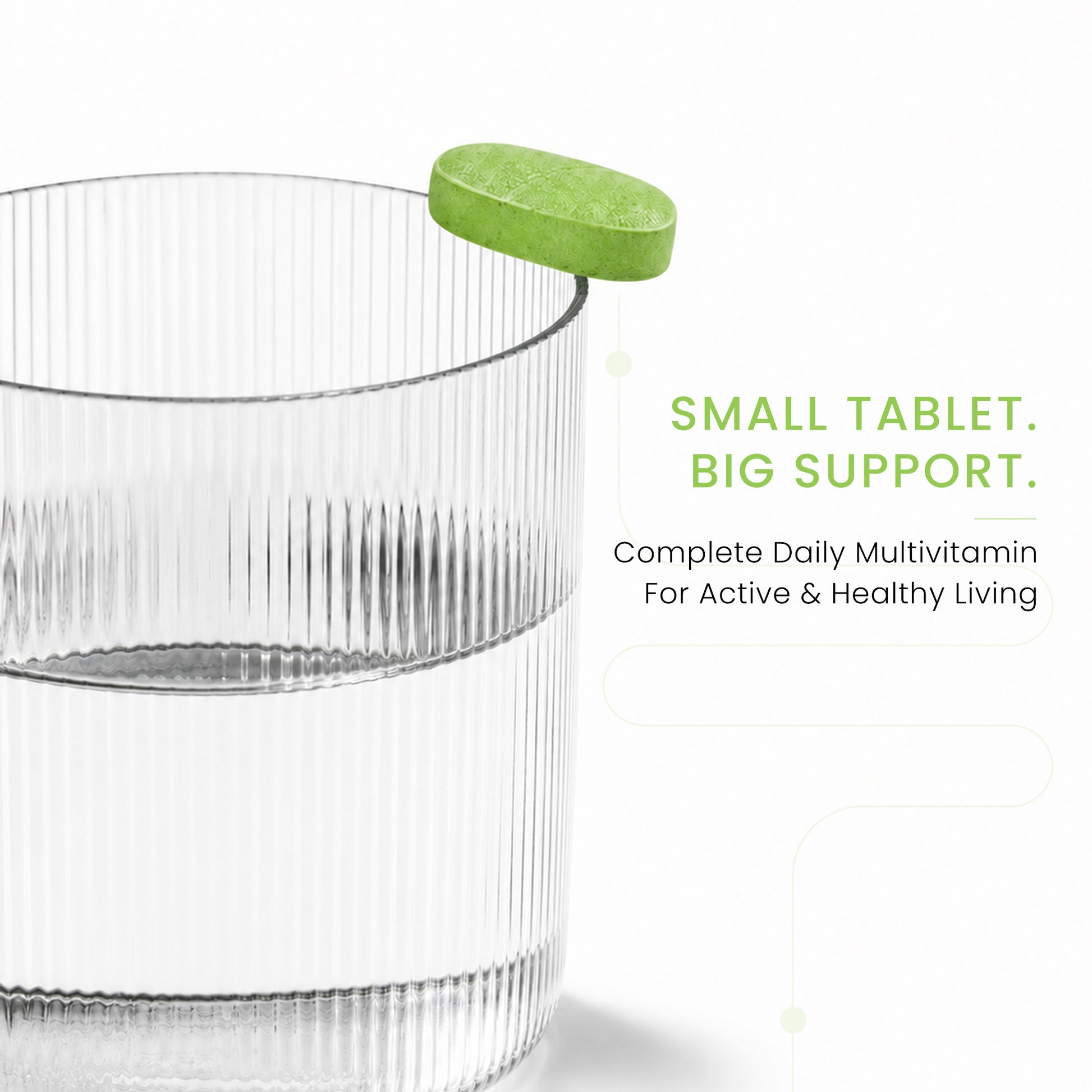 Green Ageliss daily multivitamin supplement tablet resting on the rim of a clear glass of water.