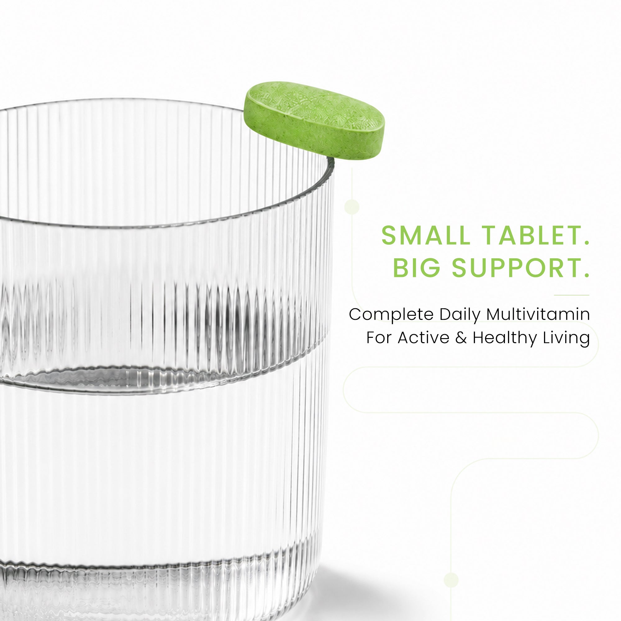 Green Ageliss daily multivitamin supplement tablet resting on the rim of a clear glass of water.